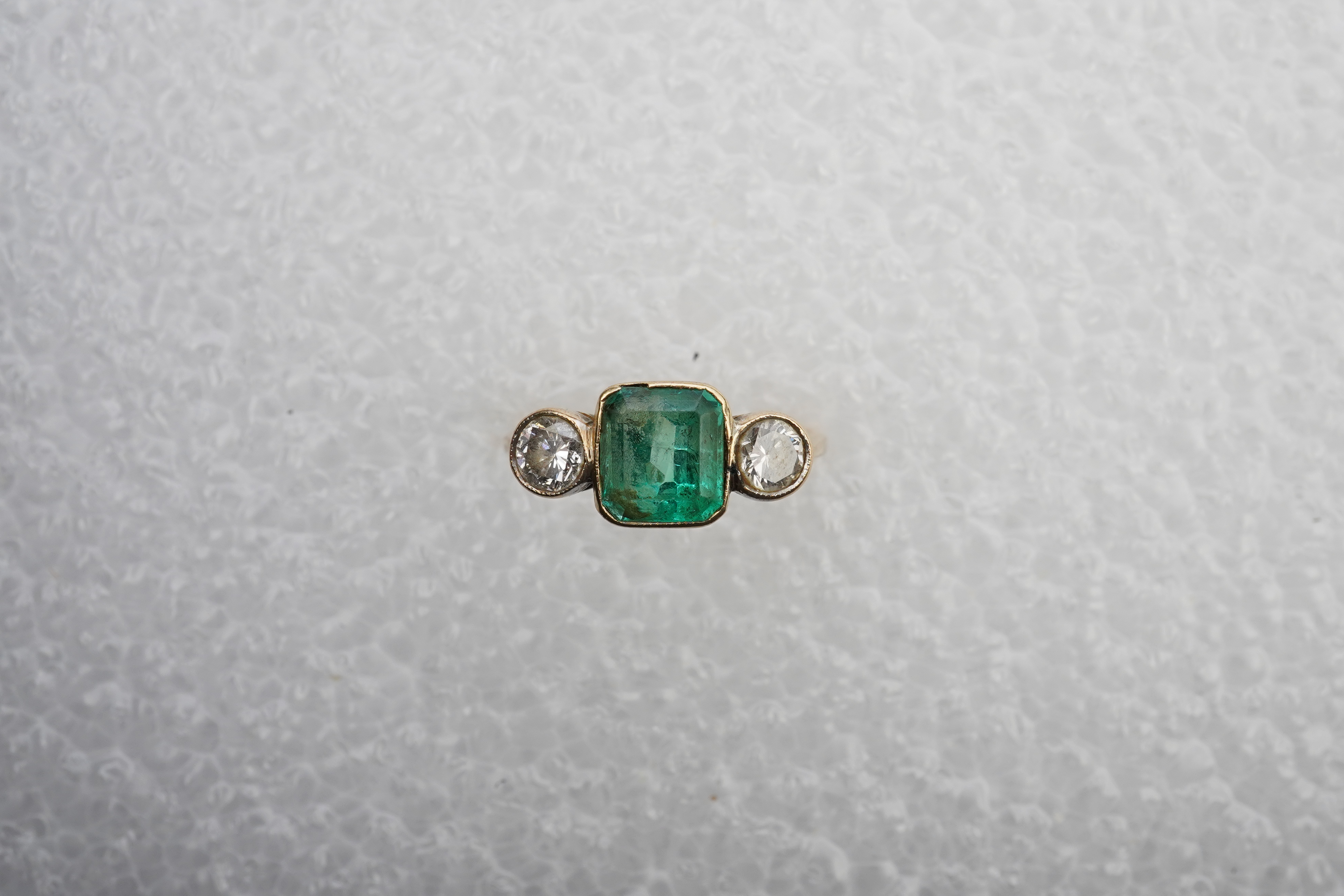 An emerald and diamond ring